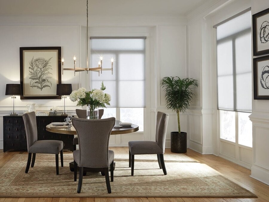 A dining room space featuring Lutron lighting and motorized shades.