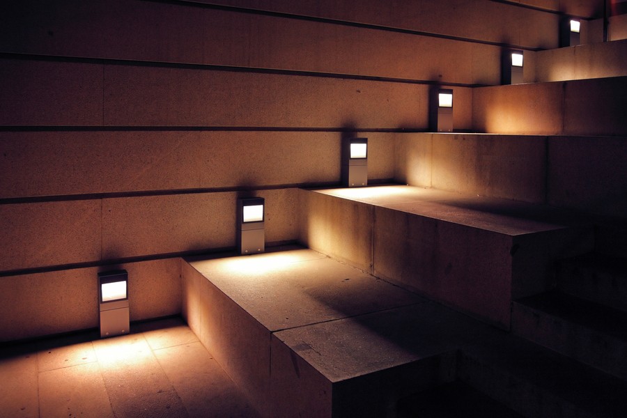 A close-up view of patio steps softly illuminated by modern side lights.