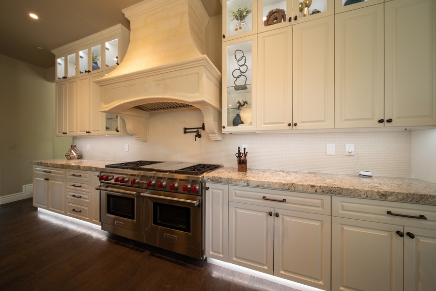 An elegant kitchen accented by under-counter and under-cabinet lighting. 